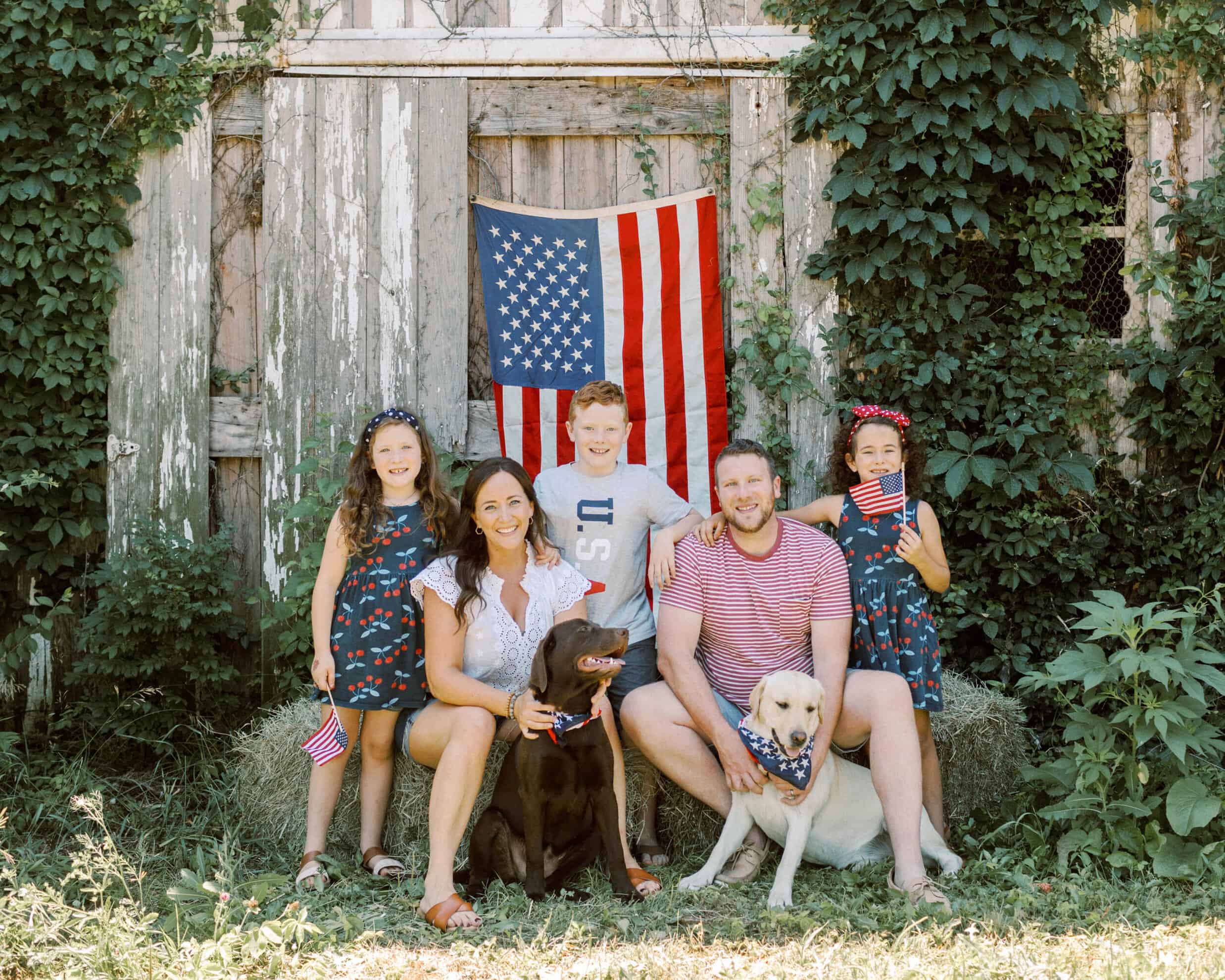 heritage creek labs indiana labrador dog breeder patriotic family photo in front of barn with chocolate and yellow labrador